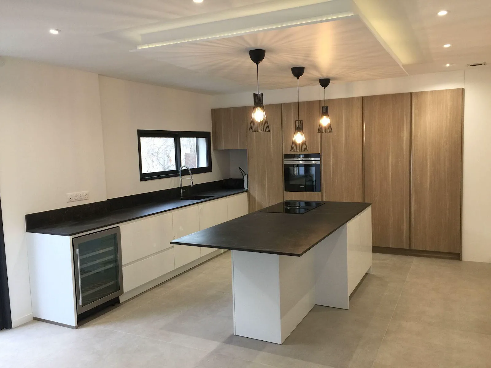 Cuisine aménagée en bois clair avec îlot central